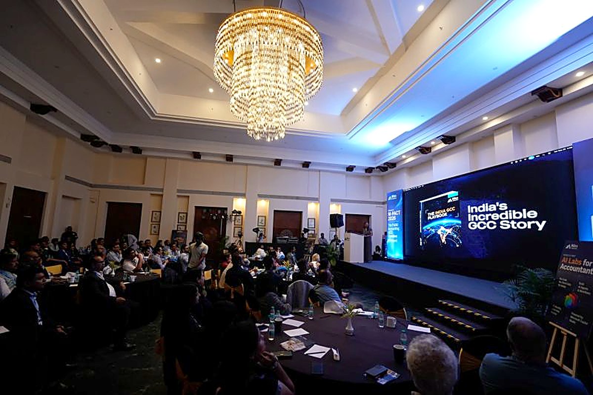 The M-Pact 2026 hall in Goa under a chandelier, the India GCC Playbook on the big screen