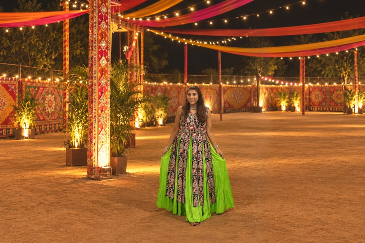 Saudamini in a green and black chaniya choli at a garba ground lit with lanterns