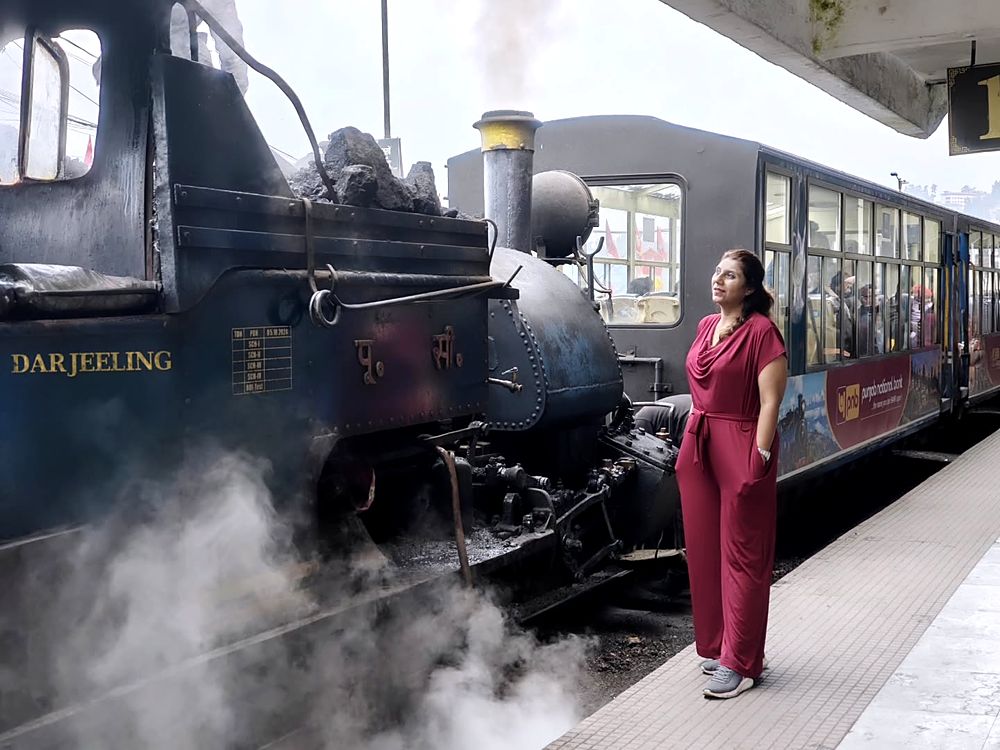 Saudamini beside the Darjeeling Himalayan Railway's steam engine, steam rising