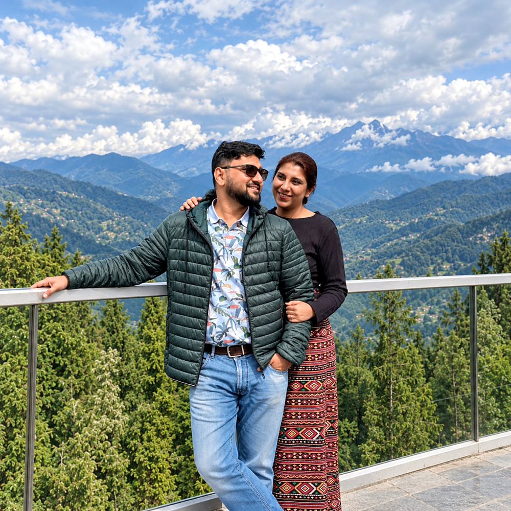 Saudamini and Shriram at a viewpoint, forested slopes and snow peaks behind