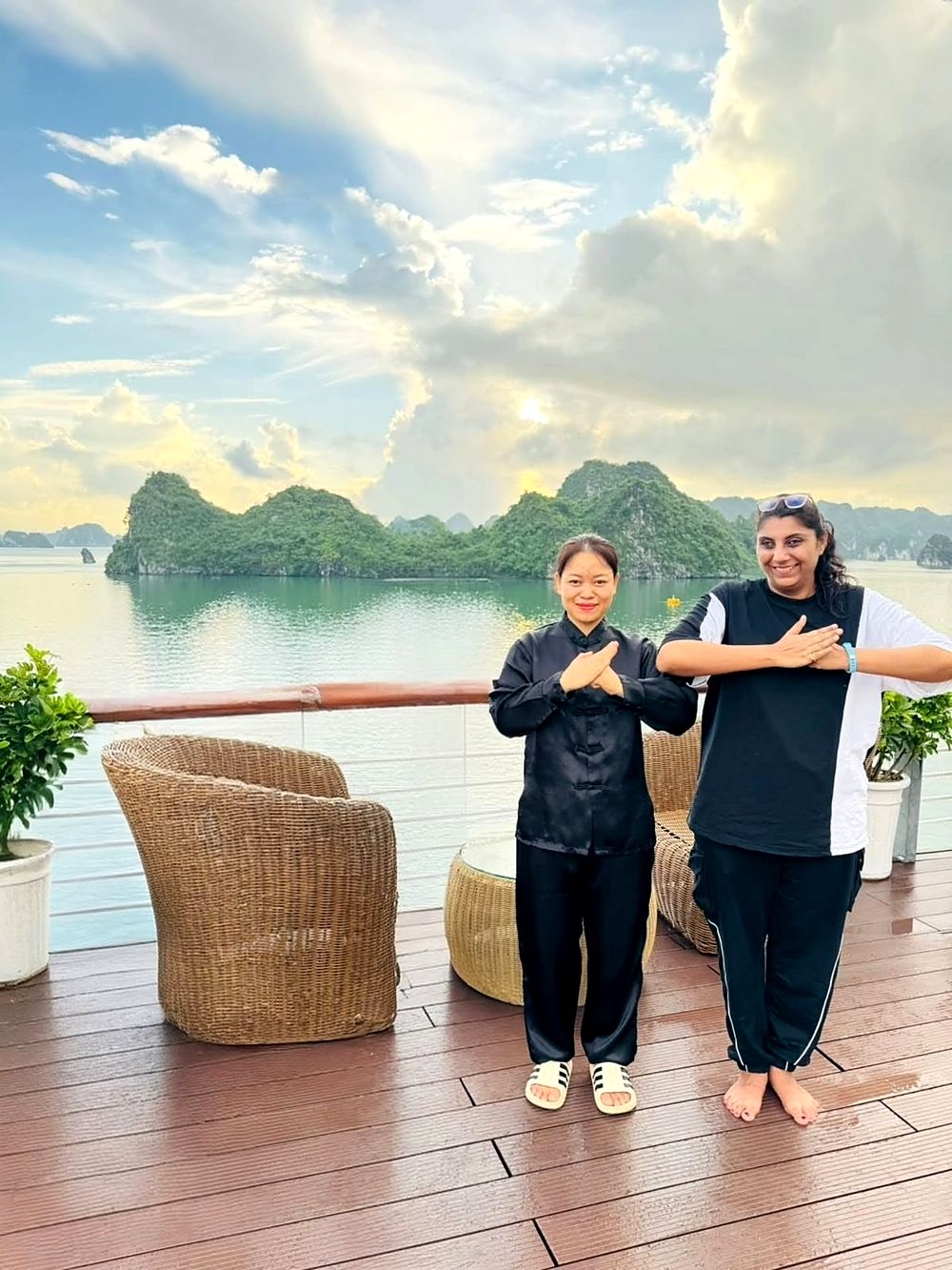 Morning tai chi on deck with the instructor, the bay behind